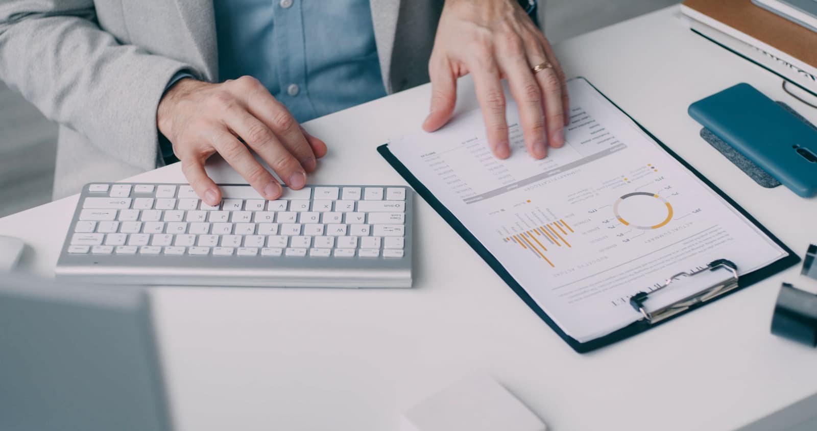 Hands reviewing a printed financial report with tables and charts